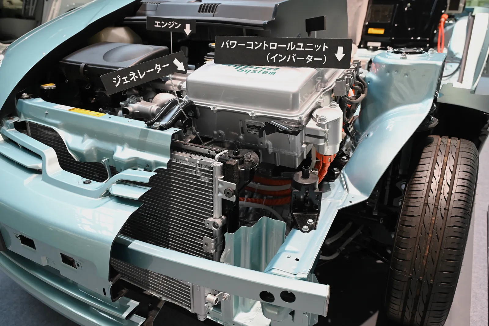 The engine bay of a first-generation Prius cutaway, with the engine, generator and power control unit labeled in Japanese
